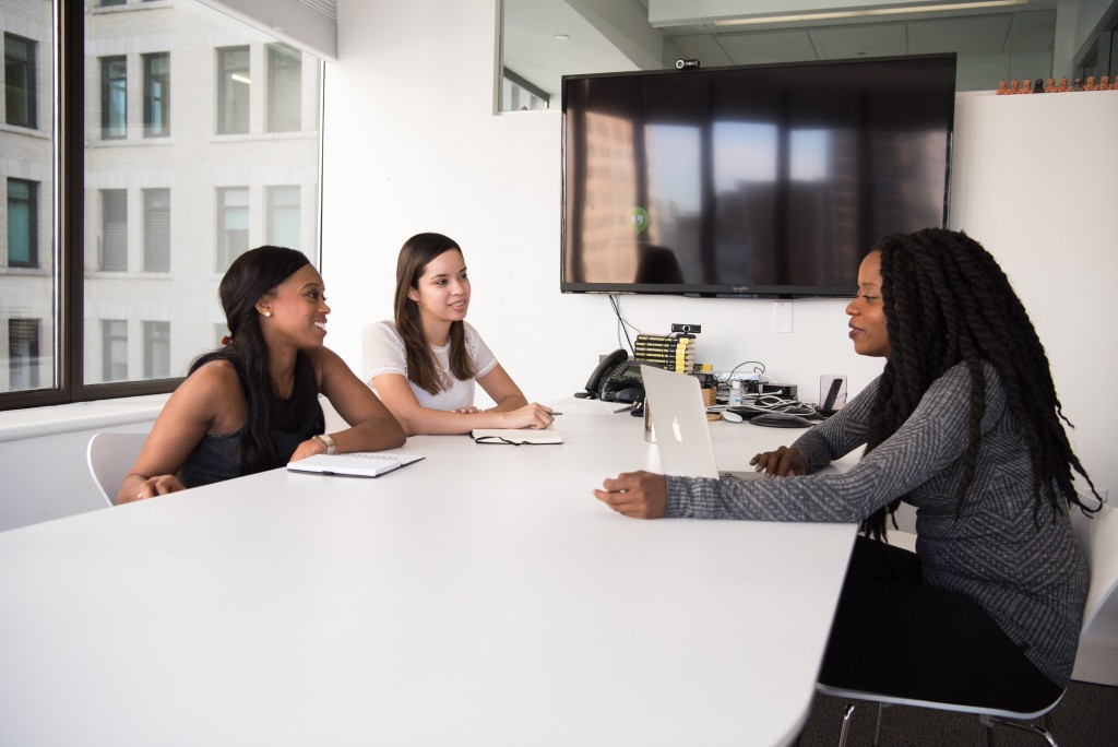 3 colleagues discussing what they found useful by using a corporate alumni program