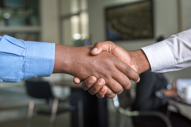 2 people shaking hands at a corporate alumni network programme