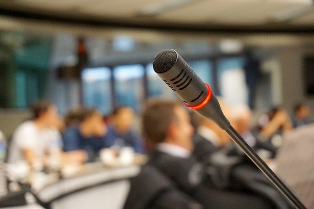 a microphone close up with a corporate alumni event in the background