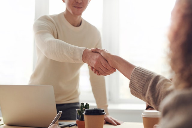 two people shaking hands after referring an employee